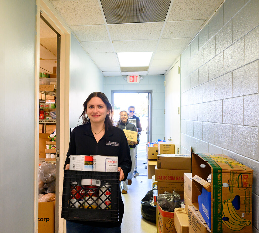 SGA member Halle Nichols, front, carries food toward Open Door Ministries’ food pantry as donations are delivered on Nov. 29.