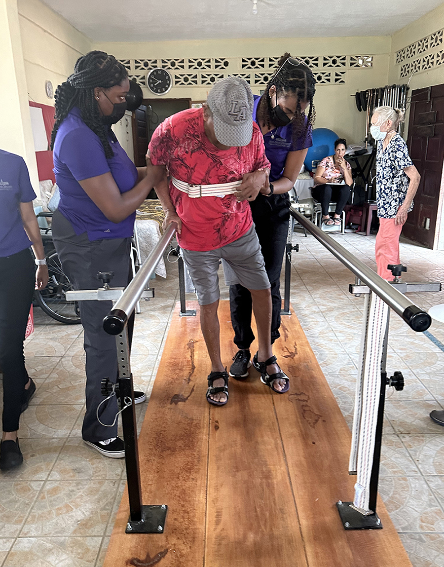 HPU physical therapy students Tolu Babalola, left, and Tamia Cofield, work with a patient in Belize.