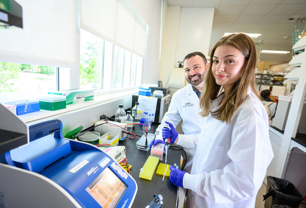 Dr. Robert Coover, left, works with Miranda Gough, a junior biology major, to analyze test results.