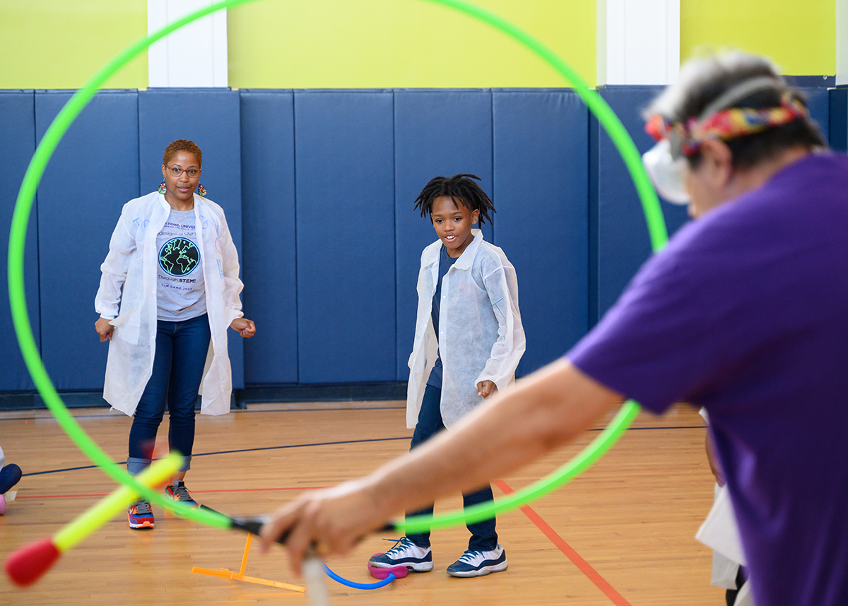 Local students learned about trajectory and inertia as they stepped on a lever and aimed for a hoop during a Mad Scientist demonstration.