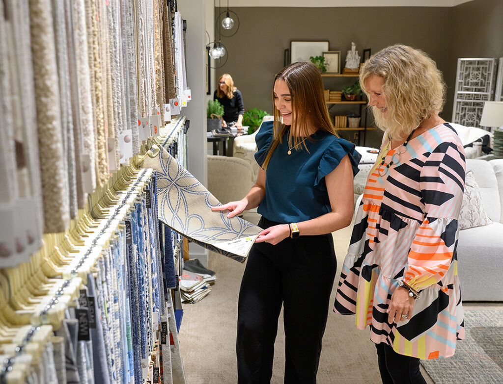 Jade Harloff, a senior interior design major from Apex, North Carolina, discusses fabric designs in the Norwalk Furniture showroom at the High Point Market.