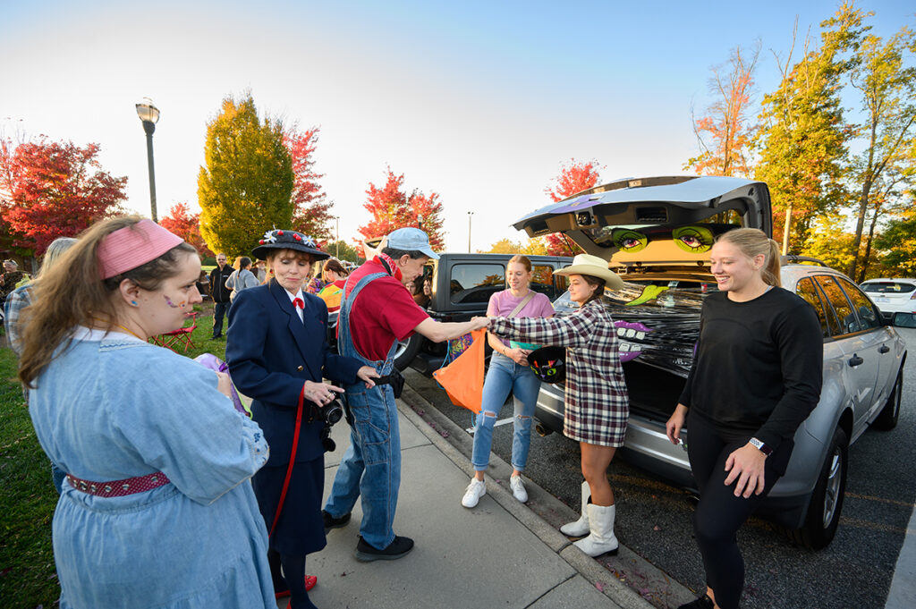HPU students share treats from the trunks of cars they decorated for Halloween.