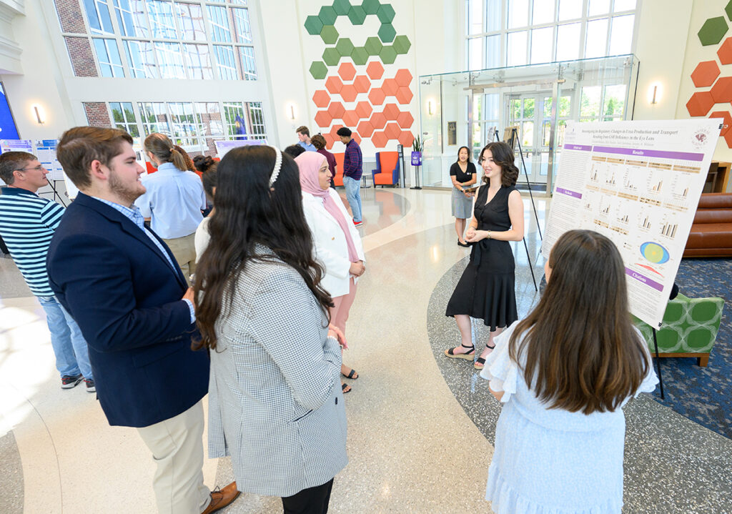 Elizabeth Rubeira, second from right, a sophomore biology major from New Bern, North Carolina, presents her SuRPS research poster. 