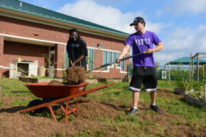 Bonner Leaders Dante Armstrong and Manning Franks complete a landscaping service project at the Macedonia Family Resource Center
