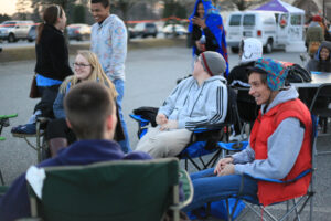 Participants chat and try to keep warm as temperatures drop.