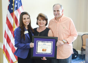 The photo features Natalie Haire with Tim and Marie Carter, owners of Carter Brothers Bar-B-Que and Ribs, who received the Campus Check-In Award.     