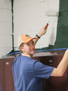 Only a short drive from HPU’s campus, a group of students gathered inside Southwest Guilford Middle School to paint the hallway for seventh graders from a dark green to a more appealing white.