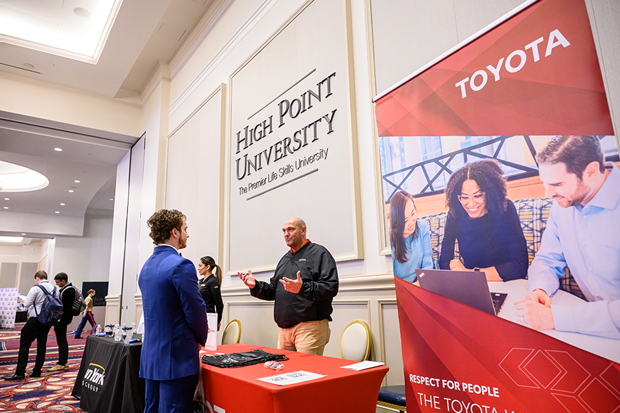 HPU Spring Career Expo, Toyiota representative speaks with a freshman