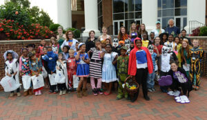 HPU students and the 50 local children stand together in front of the Wanek Center on campus before their Halloween adventure began.