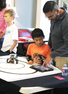 Local children and their parents work with Lego robotics to further enhance their understanding of science, technology, engineering and math (STEM). 