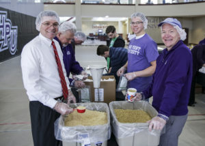 Clockwise from left, Dr. Jim Wehrley, dean of the Phillips School of Business at HPU; Michael Dutcher, HPU student; and Scott Davis, associate professor of accounting at HPU, pack meals for Meals of Hope during last year's Day of Service. 