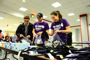 HPU students Jose San Miguel, Manning Franks and Alysandra Zuber pack kits of essential items to be distributed to the homeless.
