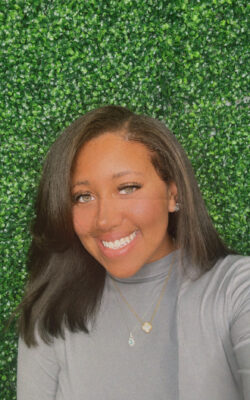 HPU Student Morgan Smith Headshot in front of wall of greenery