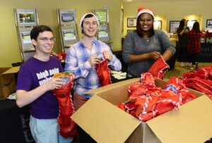 From left to right, HPU students David Holmes, G.R Dulac and Jordan Bydume fill stockings for the Salvation Army.