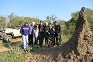 Students are pictured with a giant termite mound in South Africa.