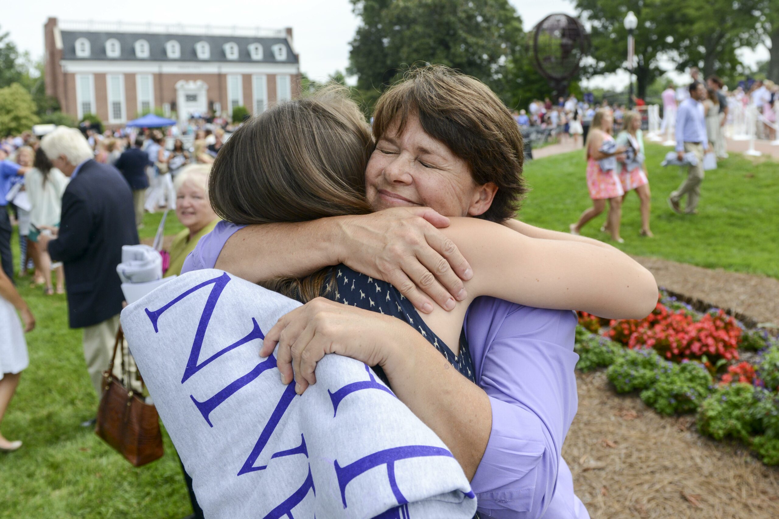 Kirby Napinsky hugging mom and giving HPU blanket at Convocation