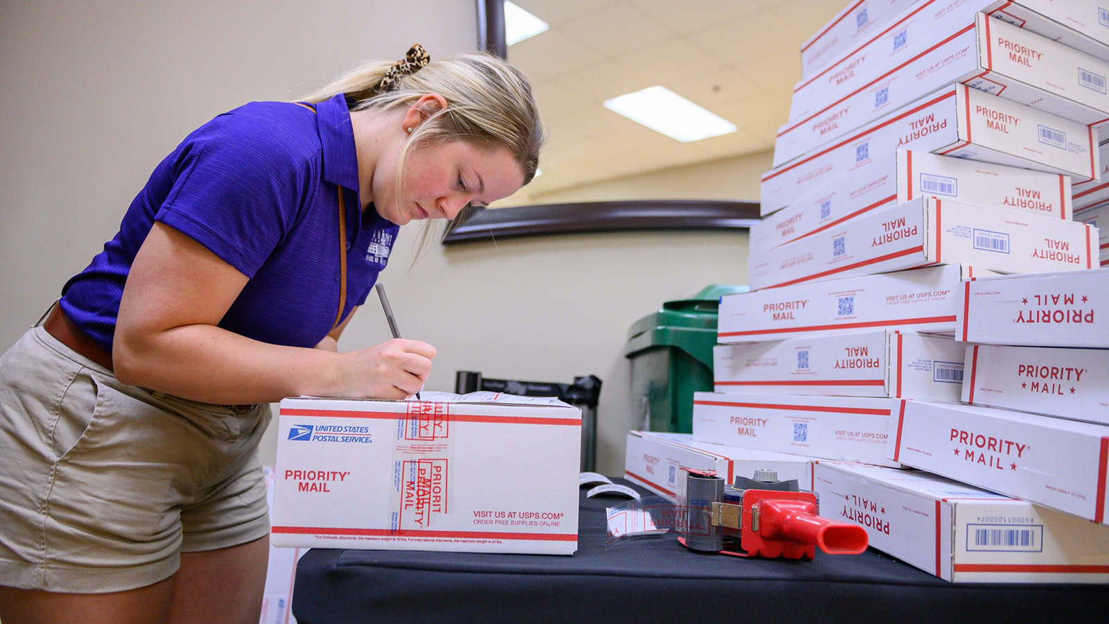Mail center staff sorting Priority Mail boxes